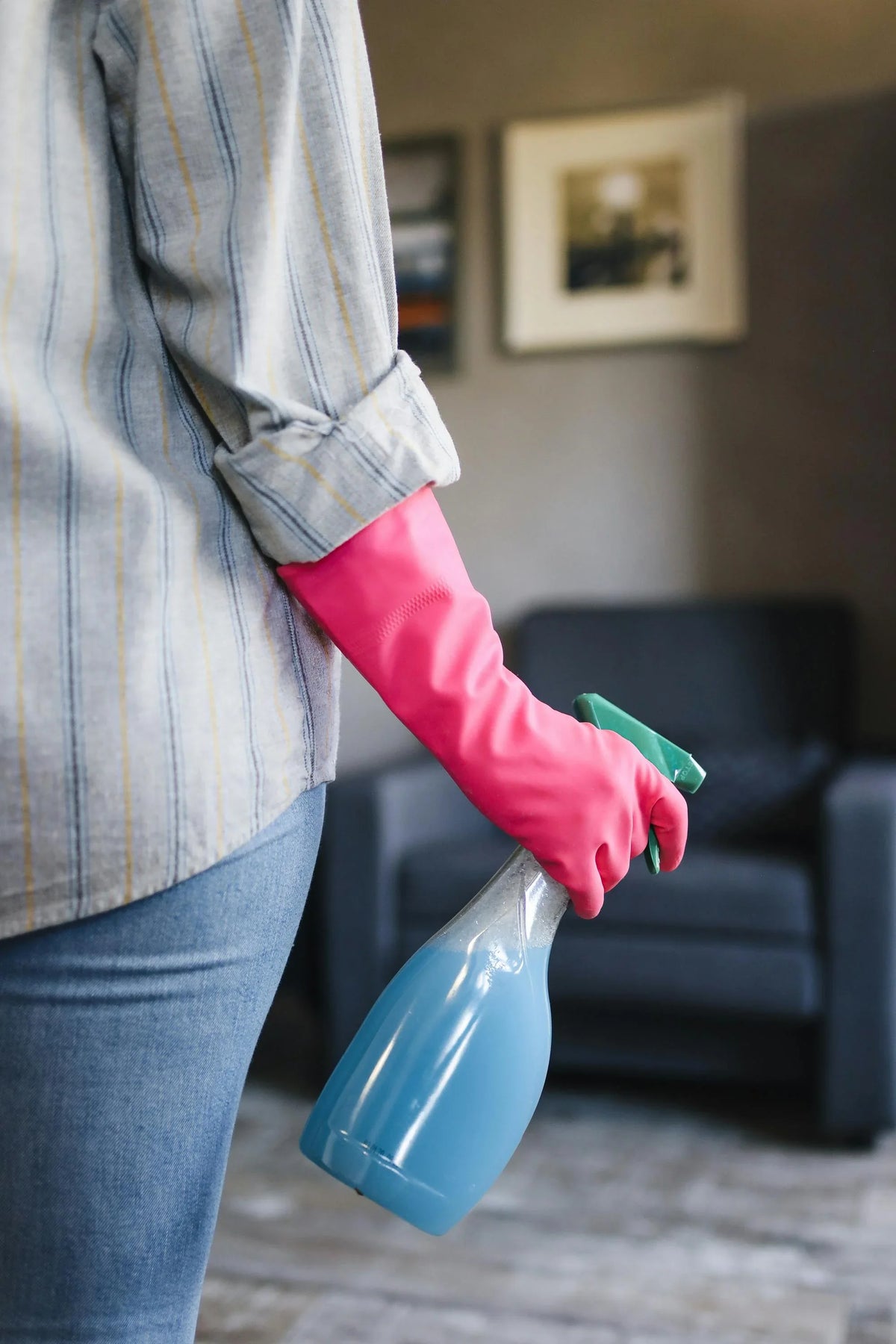 Personne tenant un spray ménager dans un intérieur propre