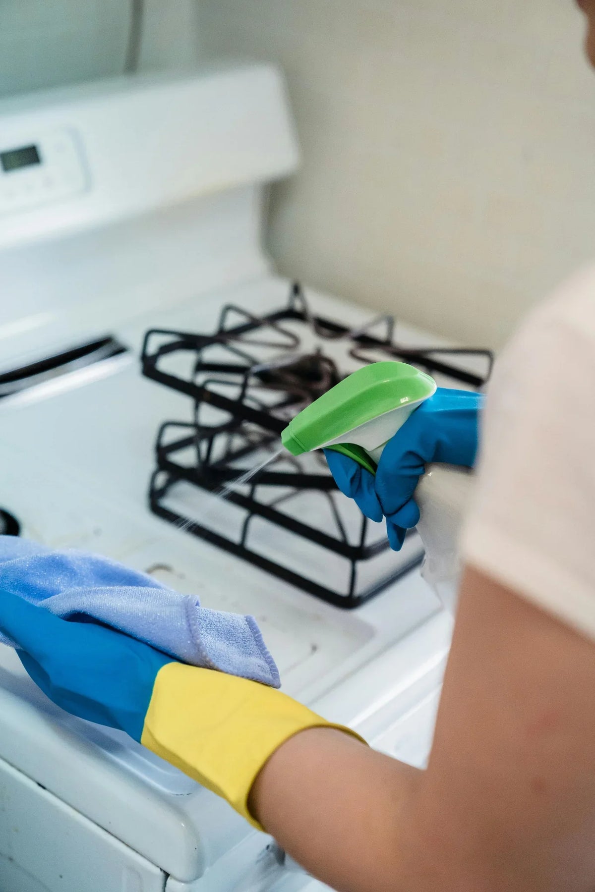 Nettoyage d’une plaque de cuisson avec un chiffon et un spray